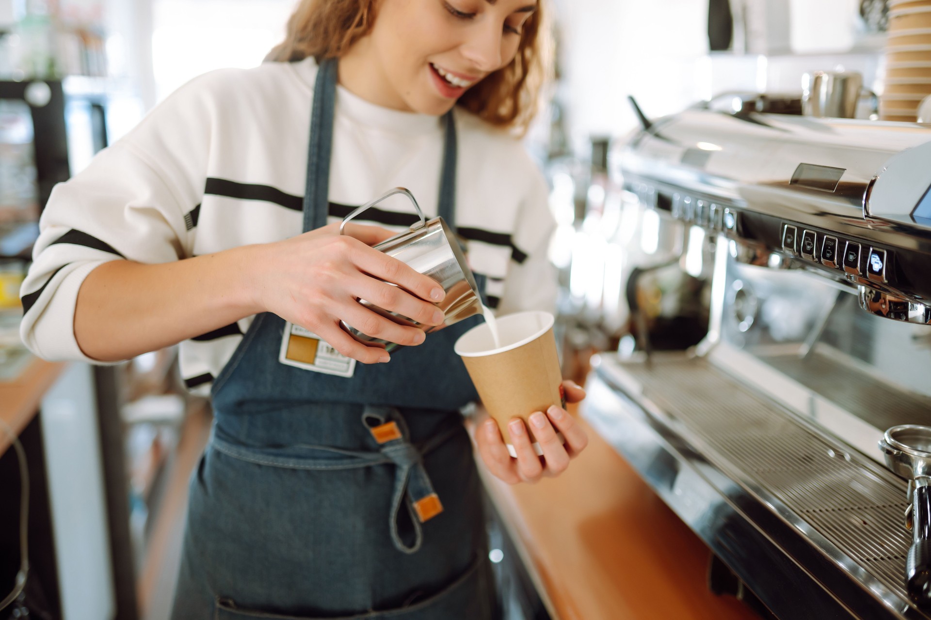 Barista holding cup getting fresh coffee that being brewed by the machine in cafe. Barista holding cup getting fresh coffee that being brewed by the machine in cafe.
